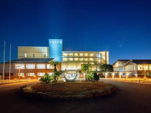 a large building with palm trees in front of it at TennenOnsen Hinatanoyado Nichinan Miyazaki - Vacation STAY 18651v in Nichinan