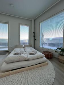 a bedroom with a large bed with two large windows at Penthouse in the city center in Rovaniemi