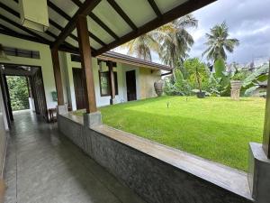 a porch of a house with a grass yard at Rockydale Home Stay in Kandy