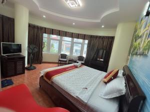 a bedroom with a large bed and a television at Hotel Nam Sơn in Dực Liễn