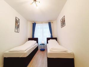 two beds in a room with a window at central 3 Bedroom Apartment in Kreuzberg in Berlin