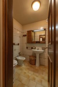 un bagno con due lavandini, un water e uno specchio di Casa alla Sorgente, con vista panoramica a San Vito di Cadore Altre 15 foto
