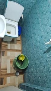 La salle de bains est pourvue de toilettes et d'une plaque verte. dans l'établissement Vrindavan Nivas -Near Prem mandir bankey bihari, à Vrindavan
