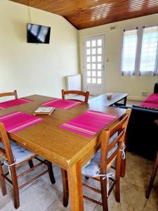 una mesa de comedor con alfombras rosas. en La Colline d'Estaing, Maison 4 pers avec terrasse en Estaing