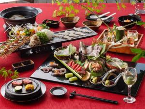 una mesa con platos de comida en una mesa roja en TennenOnsen Hinatanoyado Nichinan Miyazaki - Vacation STAY 18655v, en Nichinan