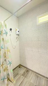 a shower in a bathroom with a shower curtain at Makorn Nonkleng in Ban Yung