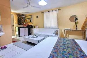 a bedroom with a bed and a living room at LOFTY DIANI STUDIO'S in Kwale