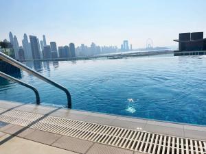 a swimming pool with a city skyline in the background at Seven Palm, Private beach, Infinity Pool, High Floor 3BDR in Dubai