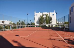 a tennis court in front of a building at Élégant appartement de 3 chambres vue piscine n4 in M'diq