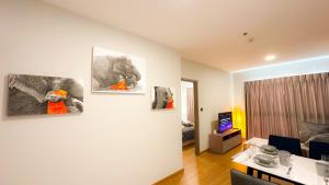 a living room with three pictures on the wall at Astra Sky River Chang Khlan Chiang Mai in Chiang Mai