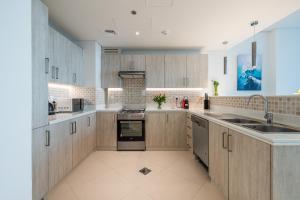 a large kitchen with wooden cabinets and appliances at Seven Palm, Private beach, Infinity Pool, High Floor 3BDR in Dubai