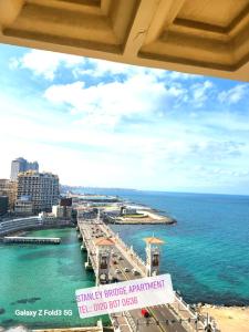 a view of a pier with the ocean and buildings at Stanley Bridge Apartment in Alexandria