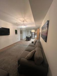 a living room with a brown couch and a kitchen at NOHO 1BR w Parking in Los Angeles