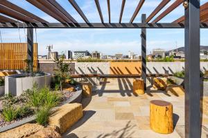 a patio with a table and benches on a roof at Hobart CBD Roof Top Penthouse in Hobart
