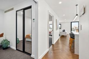 a room with white walls and a hallway with sliding glass doors at Hobart CBD Roof Top Penthouse in Hobart