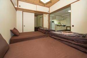 twee bedden in een kamer met een keuken bij 直前半額プライベート個室トイレバスタブ付民泊札幌市中心部でシンプルな滞在h503#12 in Sapporo +32 foto's