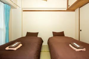 twee bedden naast elkaar in een kamer bij 直前半額プライベート個室トイレバスタブ付民泊札幌市中心部でシンプルな滞在h503#12 in Sapporo