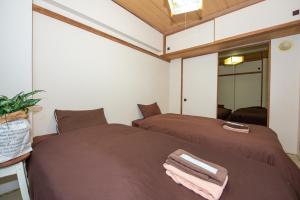 twee bedden naast elkaar in een kamer bij 直前半額プライベート個室トイレバスタブ付民泊札幌市中心部でシンプルな滞在h503#12 in Sapporo