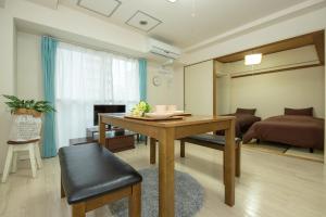 een woonkamer met een tafel en een slaapkamer bij 直前半額プライベート個室トイレバスタブ付民泊札幌市中心部でシンプルな滞在h503#12 in Sapporo