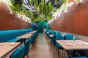 ein Restaurant mit Tischen, Stühlen und Pflanzen in der Unterkunft Treebo Trend Express Inn in Mumbai