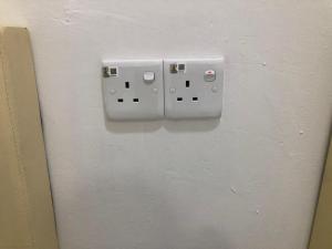 a lightswitch on a wall with a socket at SKYN SMART HOME in Ipoh
