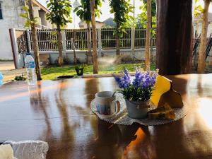 清迈188 Teak House บ้านต้นสัก的一张桌子,上面放着一杯,花紫色 更多25张照片