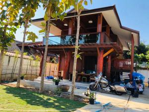 una casa con una moto parcheggiata di fronte di 188 Teak House บ้านต้นสัก a Chiang Mai