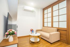 a living room with a chair and a table at Sumitomo 15 Apartment - No 27 Lane 39 Linh Lang Street in Hanoi