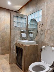 a bathroom with a toilet and a sink and a mirror at Rinna Resort in Koh Mook