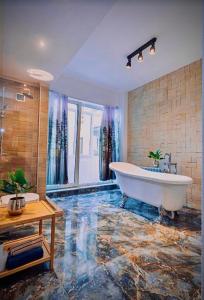 un ampio bagno con vasca e pavimento in marmo di Art Luxury Apartment - central, metro to airport a Sofia
