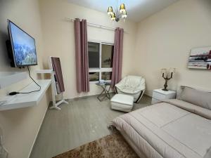 a bedroom with a bed and a tv and a couch at Your Dubai delight in Dubai