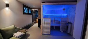 ル・モンドールにあるAlti'Pic Hôtelの青い照明付きのシャワーが備わる客室です。