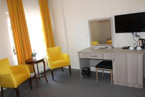 a hotel room with yellow chairs and a desk with a mirror at ANGRAND HOTEL in Ankara