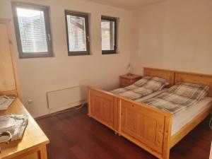 sypialnia z drewnianym łóżkiem i 2 oknami w obiekcie Chalet Montagne Bansko apartment w mieście Bansko