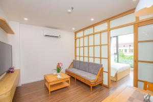 ハノイにあるSumitomo 14 Apartment - 50 Phan Ke Binh streetのソファ、ベッド、テレビが備わる客室です。