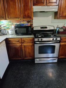 a kitchen with a stove and a microwave at Cozy, spacious and peaceful in Providence