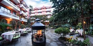 un restaurante con chimenea en un patio con mesas en Nirvana Boutique Hotel en Katmandú