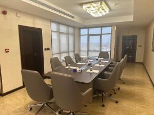 ein großer Konferenzraum mit einem langen Tisch und Stühlen in der Unterkunft Al Ertiqaa Hotel in Dschidda