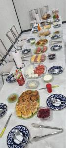 a long table with plates of food on it at YASMIN in Samarkand