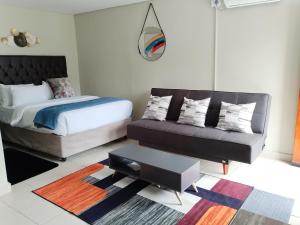 1 dormitorio con 1 cama y 1 sofá en EMPEROR LODGE AND TOURS en Germiston