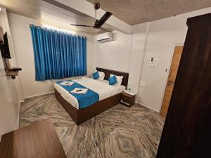 a bedroom with a bed and a blue curtain at PRIME VISTA in Navi Mumbai