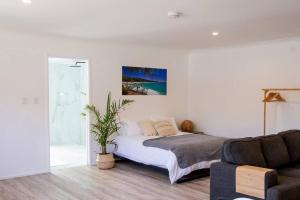 Habitación blanca con cama y sofá en Central Studio + Close to the beaches + Wifi & Netflix, en Point Lookout