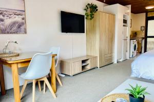 1 dormitorio con escritorio, 1 cama y TV en The Swiss Chalet Holiday Apartment 5, Bay of Islands, en Paihia