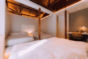 Duas camas num quarto com uma secretária e uma cama em One Harajuku: Private Oasis em Tóquio