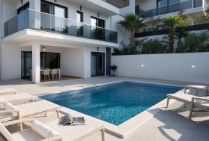 a villa with a swimming pool in front of a building at NEW ! Villa Palm Bay 1 & 2 with two heated pool - near sea in Ražanj
