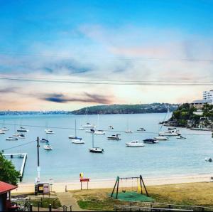 a group of boats in the water with a playground at Little Manly Getaway in Sydney