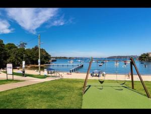 シドニーにあるLittle Manly Getawayのビーチと水辺の景色を望む遊び場