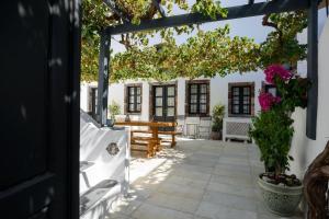 een patio met een houten tafel en een boom bij Firalia, Casa in Rock Suites in Fira