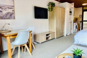 1 dormitorio con escritorio, 1 cama y TV en The Swiss Chalet Holiday Apartment 6, Bay of Islands, en Paihia