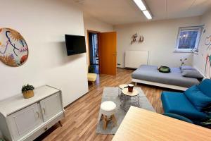 ein Wohnzimmer mit einem Sofa und einem Bett in der Unterkunft Le studio Héloïse - BeCosy rentals - 2 ad + 1 enf in Péruwelz